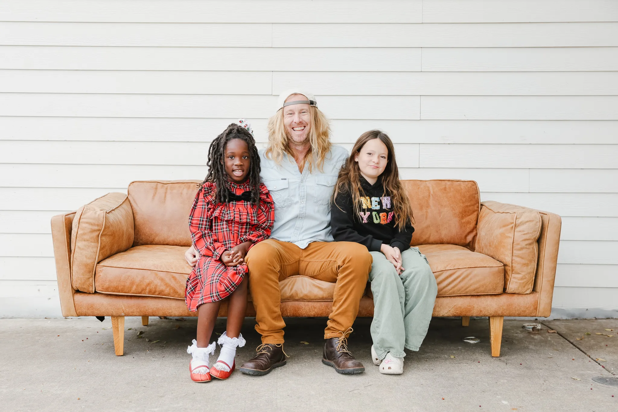 Jamey Ice with his two daughters on a tan leather couch, Fort Worth.
