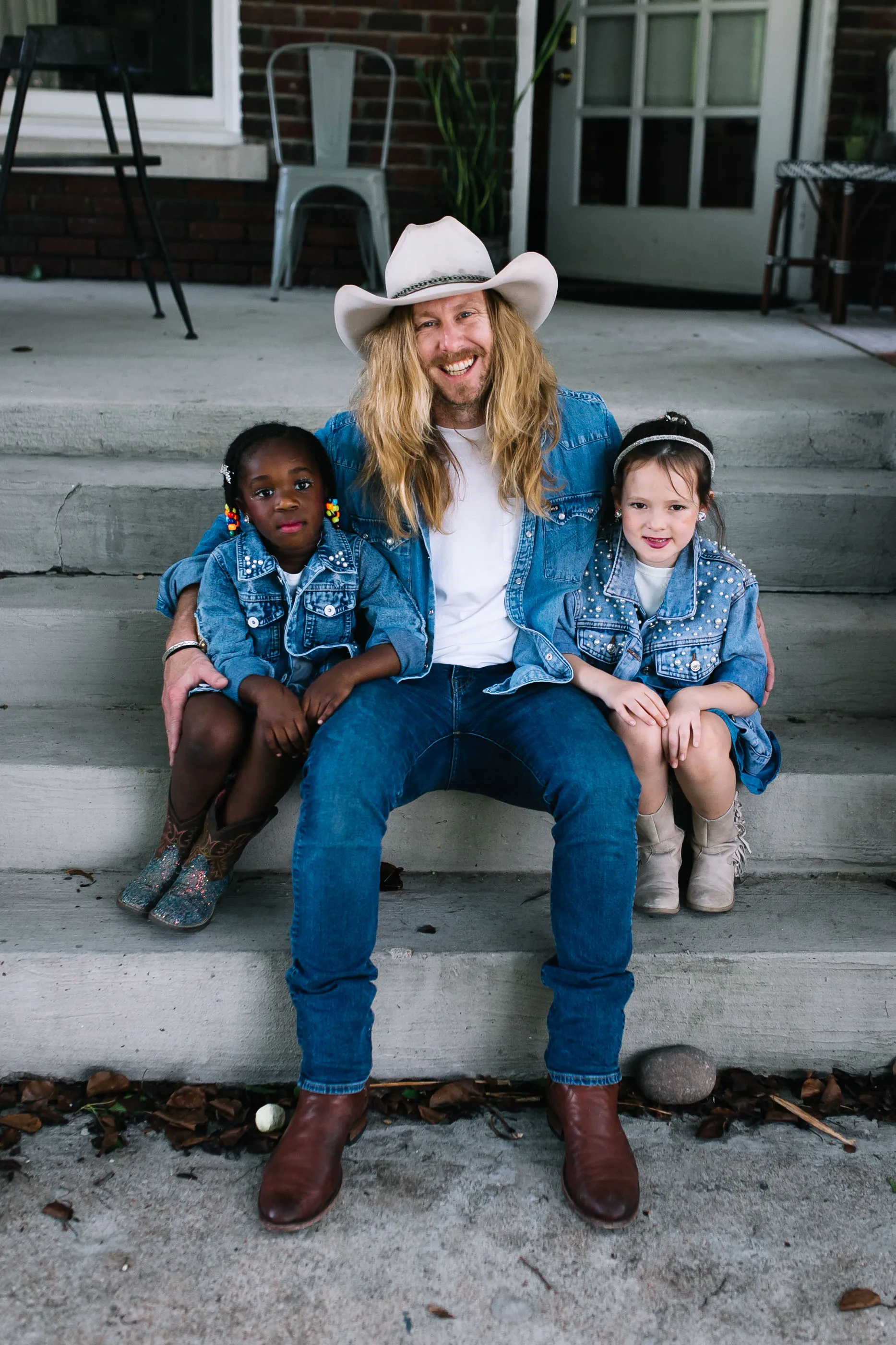Jamey Ice on porch steps with his two daughters in Fort Worth.