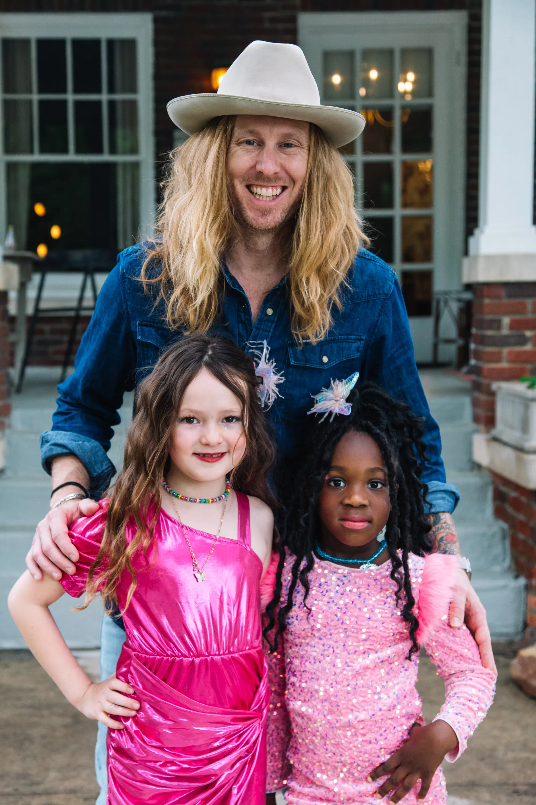 Jamey Ice in a cowboy hat with his two daughters in sparkly pink dresses.