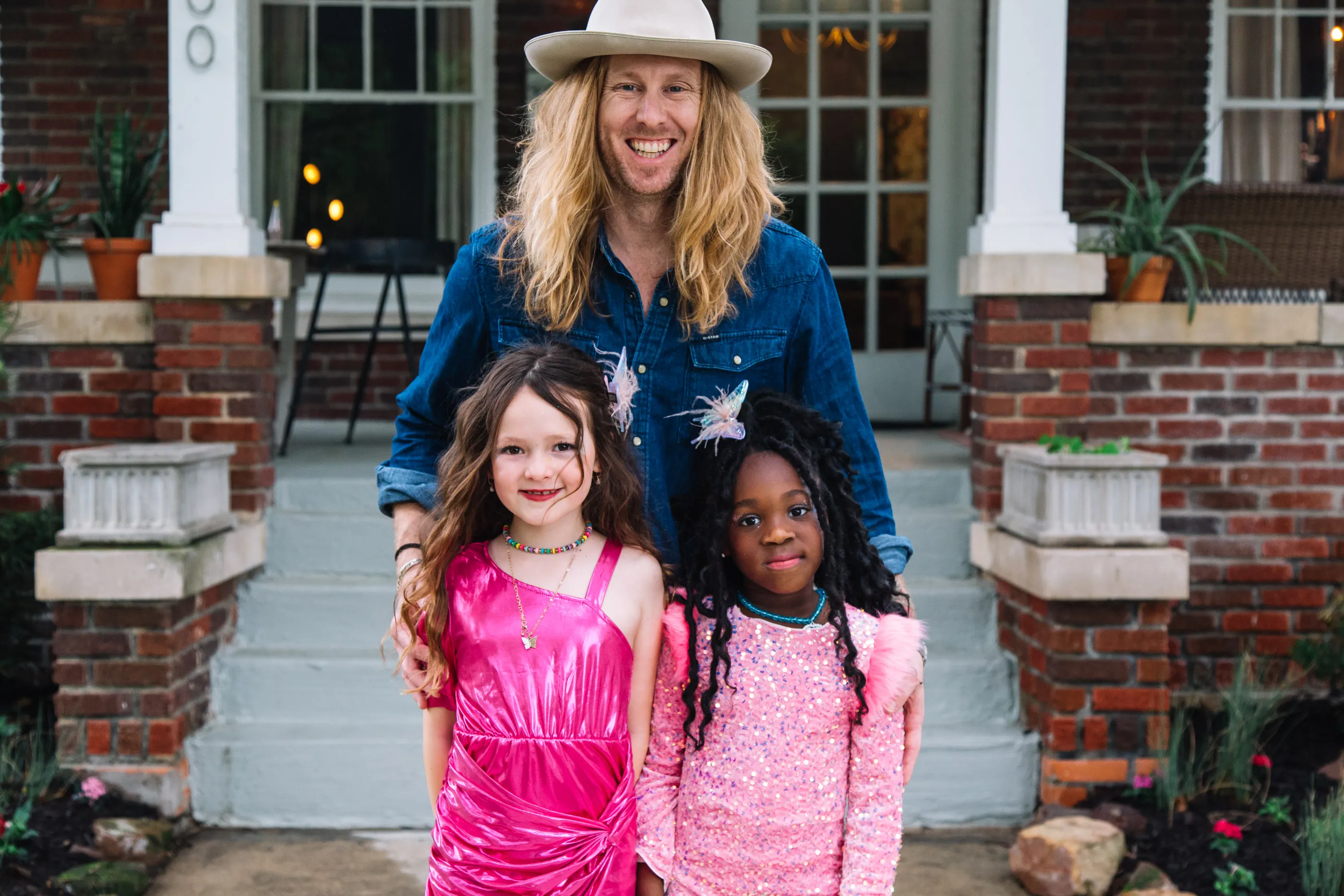 Jamey with his two daughters on a porch.